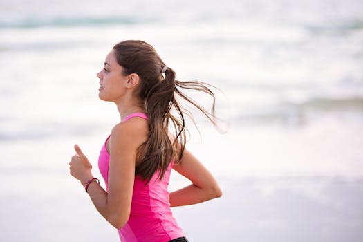 Save money while moving. Side view of a young woman jogging on a beach wearing pink active wear.